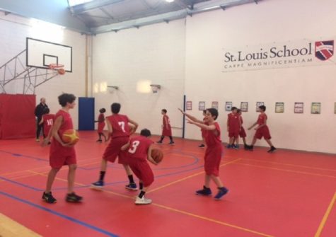 Members of the Middle School Basketball Team warm-up under the watchful eye of Mr Bell